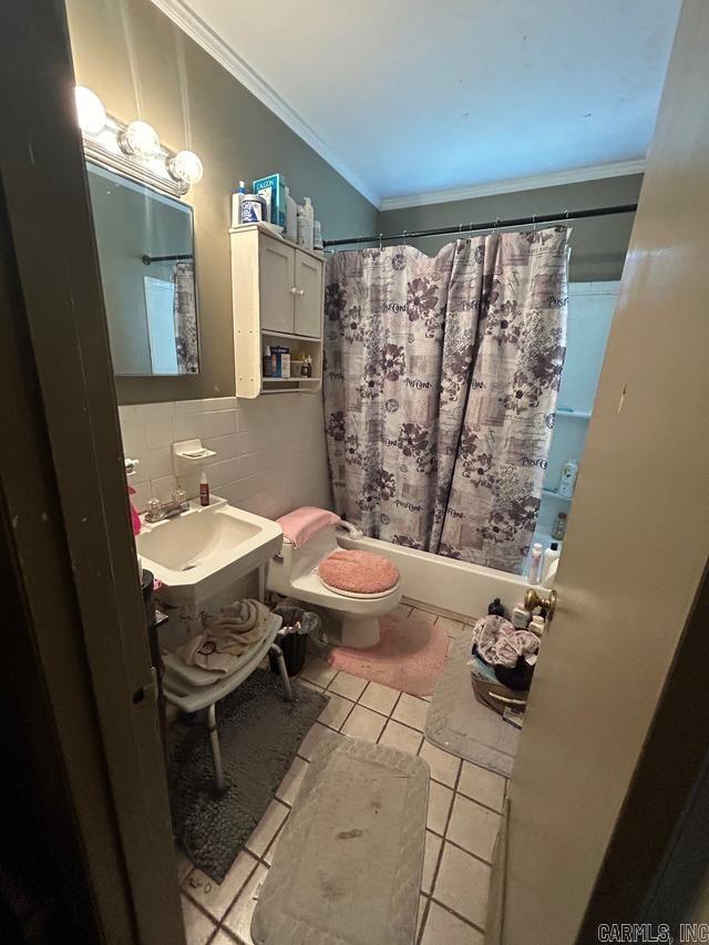 full bathroom featuring ornamental molding, shower / bathtub combination with curtain, tile patterned floors, toilet, and decorative backsplash