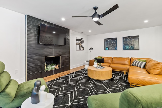 living room featuring a fireplace, dark hardwood / wood-style flooring, and ceiling fan