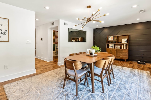 dining area featuring hardwood / wood-style floors and a notable chandelier