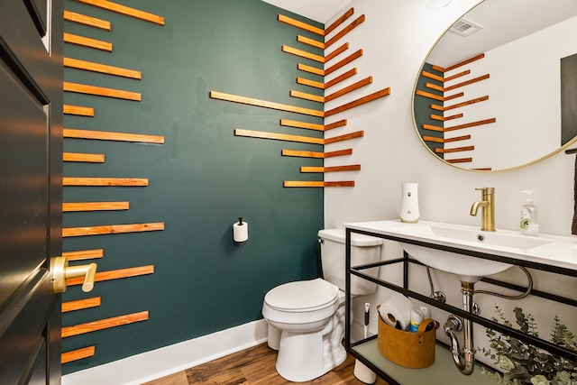 bathroom with wood-type flooring, sink, and toilet