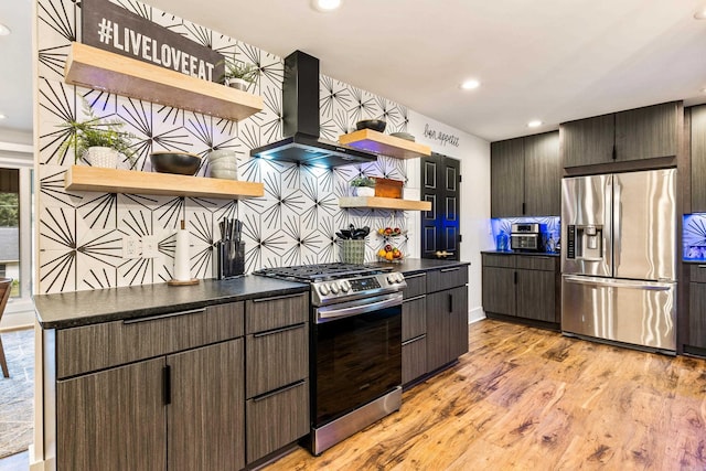 kitchen featuring light wood-type flooring, stainless steel appliances, backsplash, dark brown cabinetry, and extractor fan