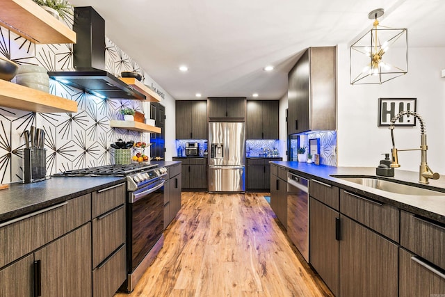 kitchen with tasteful backsplash, ventilation hood, sink, light hardwood / wood-style flooring, and appliances with stainless steel finishes