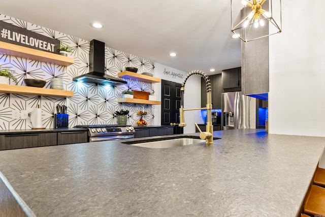 kitchen featuring appliances with stainless steel finishes, wall chimney range hood, and tasteful backsplash