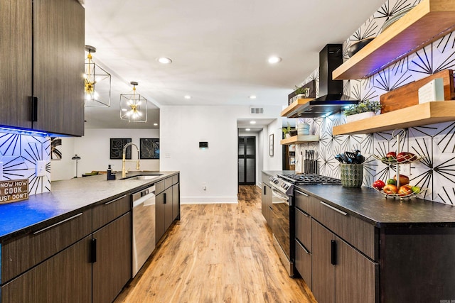 kitchen featuring appliances with stainless steel finishes, light wood-type flooring, dark brown cabinetry, sink, and extractor fan