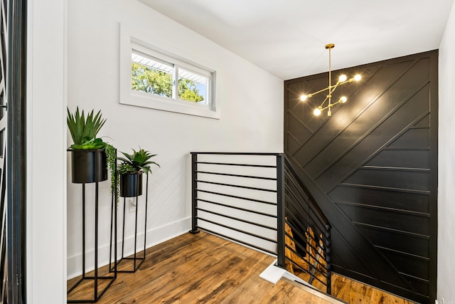 staircase featuring an inviting chandelier and hardwood / wood-style floors