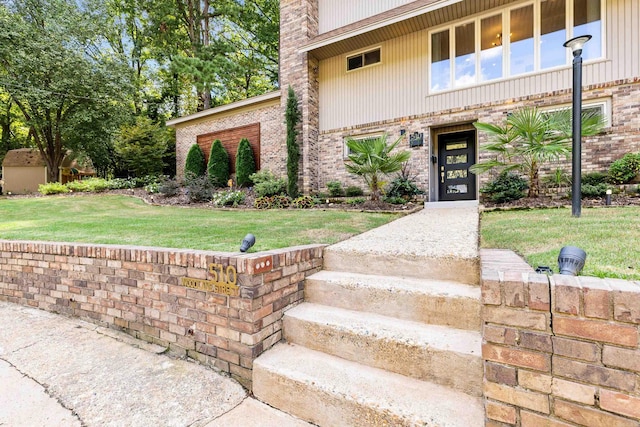 entrance to property featuring a lawn