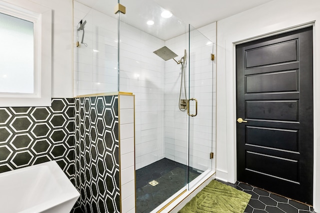 bathroom featuring independent shower and bath, tile walls, and sink