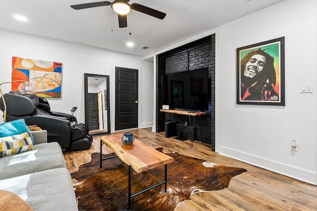 living room with wood-type flooring and ceiling fan