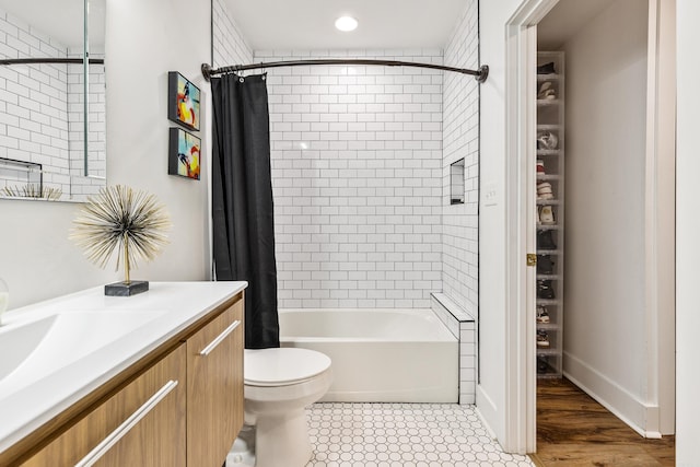 full bathroom with shower / tub combo with curtain, hardwood / wood-style floors, vanity, and toilet