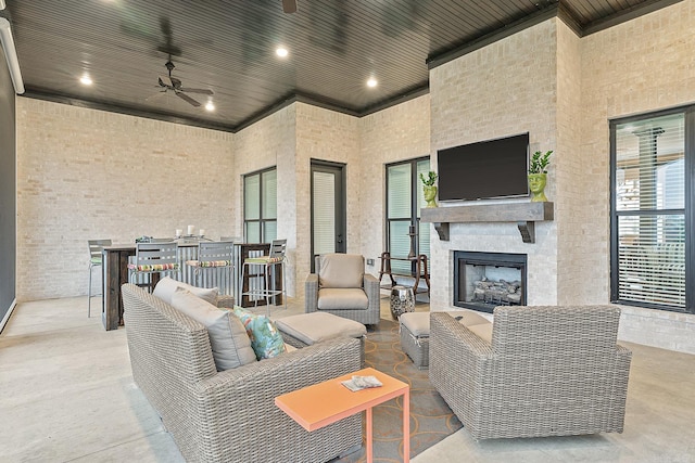 view of patio / terrace with an outdoor living space with a fireplace and ceiling fan