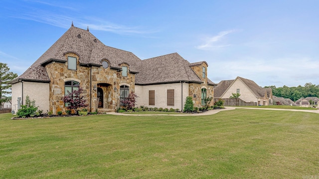 french country inspired facade featuring a front yard