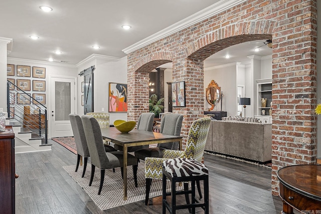 dining room featuring brick wall, ornamental molding, and hardwood / wood-style flooring