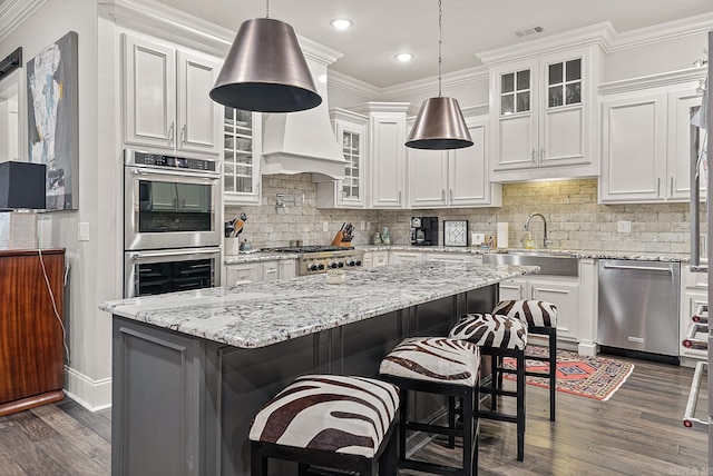 kitchen featuring sink, pendant lighting, stainless steel appliances, and white cabinets