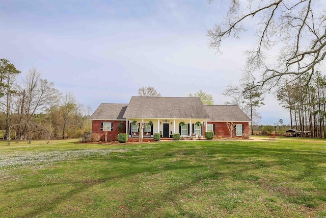 view of front of home featuring brick siding, covered porch, and a front lawn