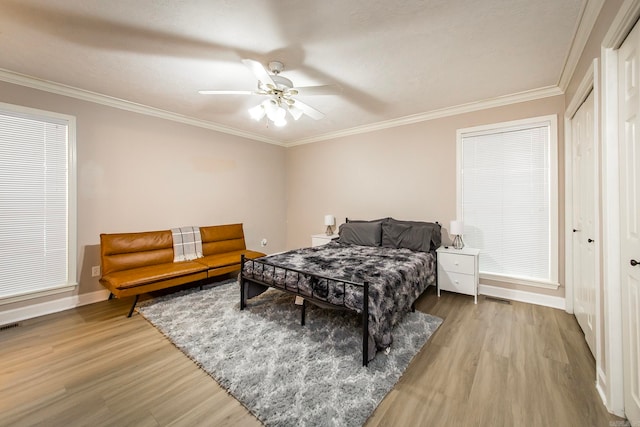 bedroom with ceiling fan, hardwood / wood-style flooring, ornamental molding, and a textured ceiling