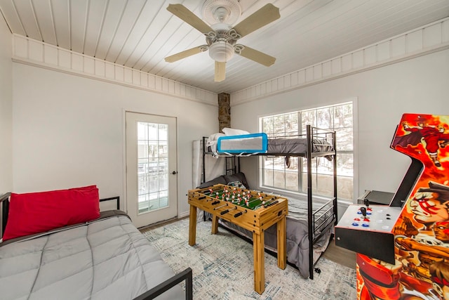 bedroom featuring ceiling fan, light wood-type flooring, access to exterior, and multiple windows