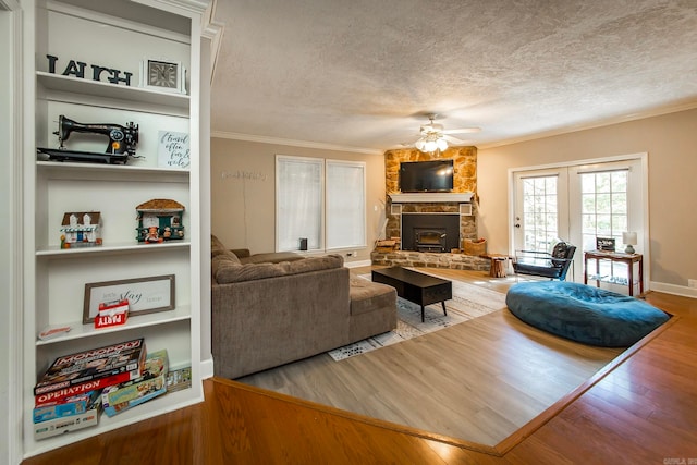 living room featuring a textured ceiling, wood-type flooring, ornamental molding, and ceiling fan