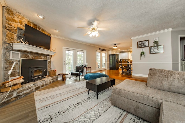 living room featuring wood-type flooring, a textured ceiling, and crown molding