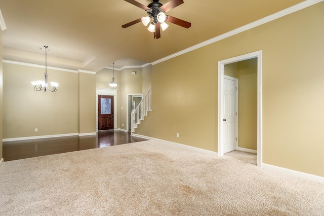 empty room featuring ceiling fan with notable chandelier, carpet floors, and crown molding