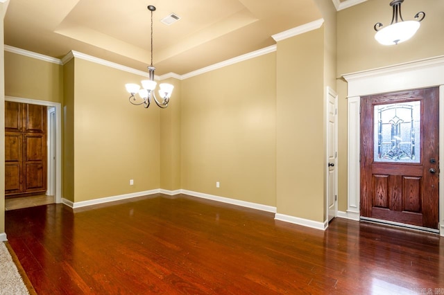 foyer entrance with a raised ceiling, dark hardwood / wood-style floors, and crown molding