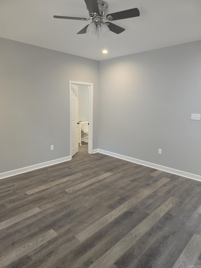 empty room with ceiling fan and dark hardwood / wood-style flooring