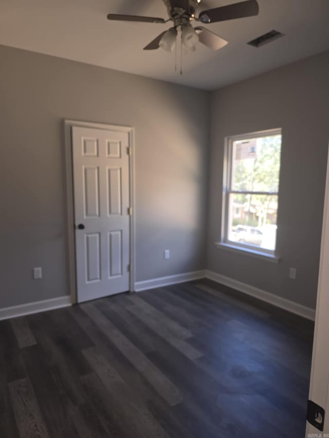 spare room featuring ceiling fan and dark hardwood / wood-style flooring