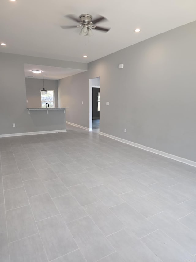 unfurnished living room featuring ceiling fan