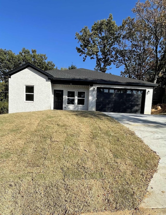 view of front of house featuring a front lawn and a garage