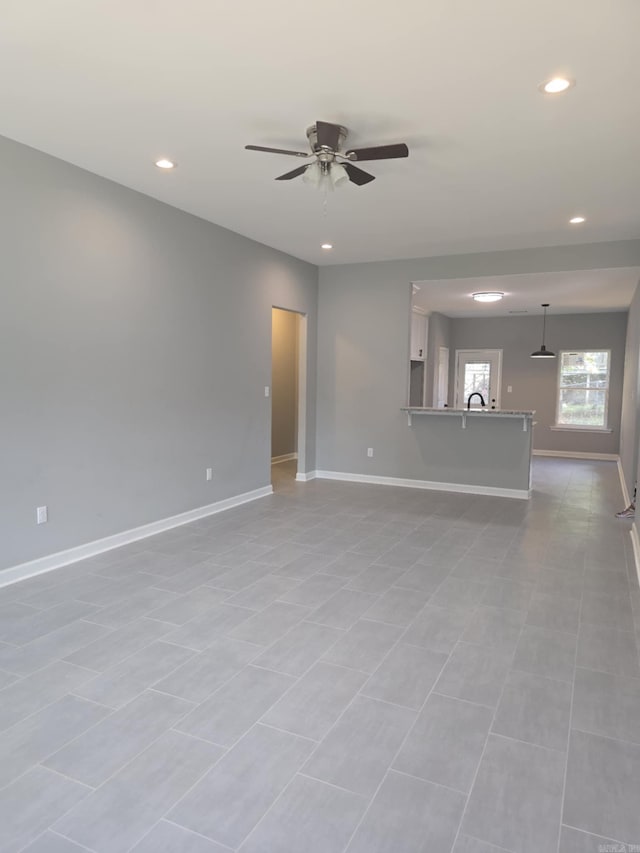 unfurnished living room featuring light tile patterned floors and ceiling fan