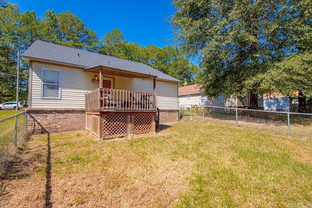 rear view of house with a yard and a wooden deck