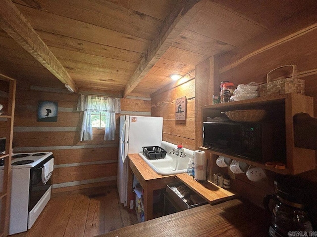 kitchen featuring beam ceiling, wooden walls, white appliances, and wood-type flooring