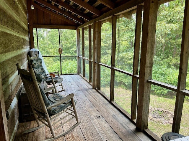 unfurnished sunroom with vaulted ceiling with beams and plenty of natural light