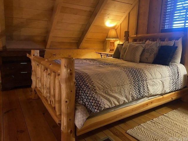 bedroom with vaulted ceiling with beams, wood ceiling, wood walls, and dark wood-type flooring