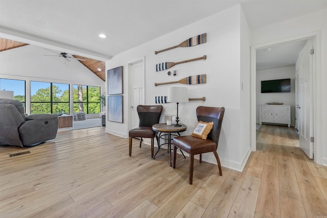 living area with vaulted ceiling with beams, light hardwood / wood-style floors, and ceiling fan