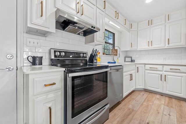 kitchen with white cabinets, sink, light hardwood / wood-style flooring, backsplash, and stainless steel appliances