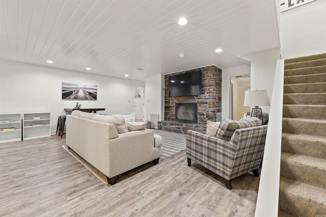 living room featuring wooden ceiling, a fireplace, and light hardwood / wood-style flooring