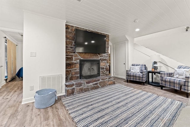 living room featuring wooden ceiling, wood-type flooring, and a fireplace