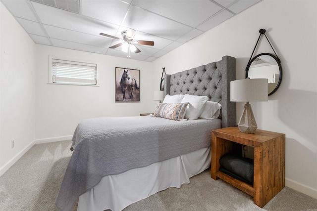 bedroom with a drop ceiling, ceiling fan, and light colored carpet