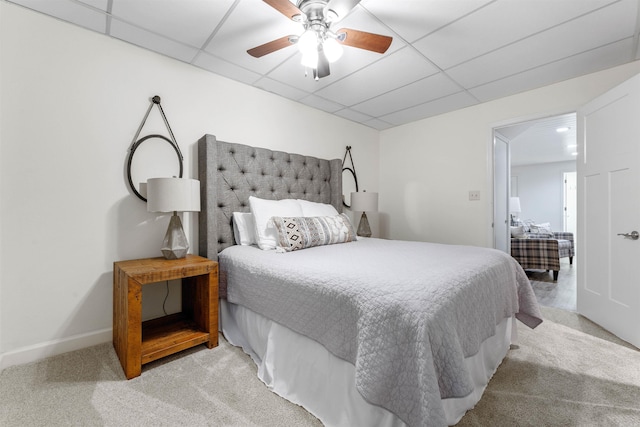 bedroom featuring light carpet, ceiling fan, and a paneled ceiling