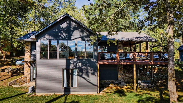 rear view of house with a wooden deck and a lawn