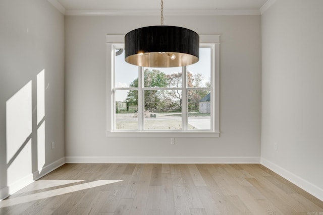 unfurnished dining area featuring ornamental molding and light wood-type flooring