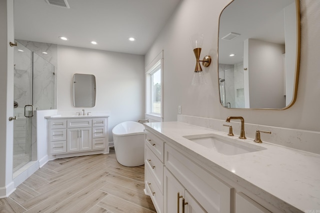 bathroom with vanity and shower with separate bathtub