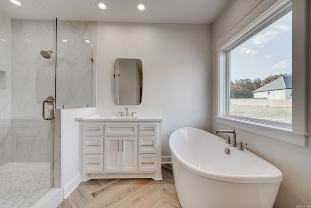 bathroom featuring vanity and independent shower and bath