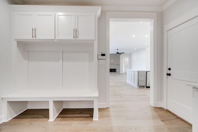 mudroom with light hardwood / wood-style floors, a large fireplace, and ceiling fan