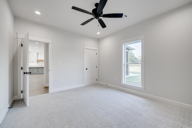 unfurnished bedroom featuring light colored carpet and ceiling fan