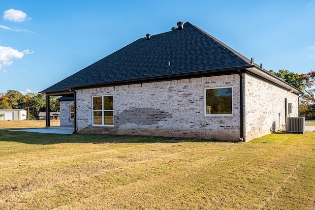 view of side of property featuring a patio area, central AC, and a yard