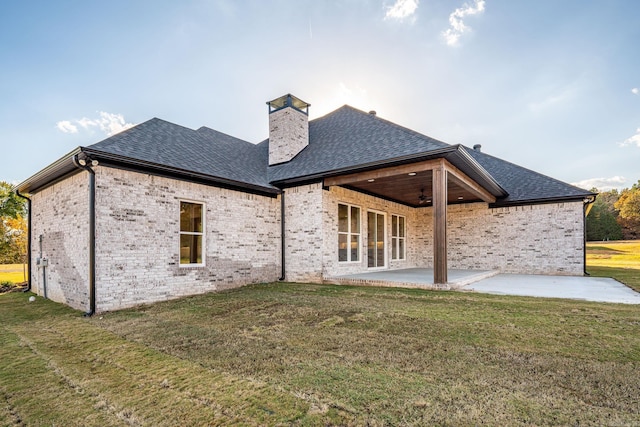 rear view of house with a yard and a patio