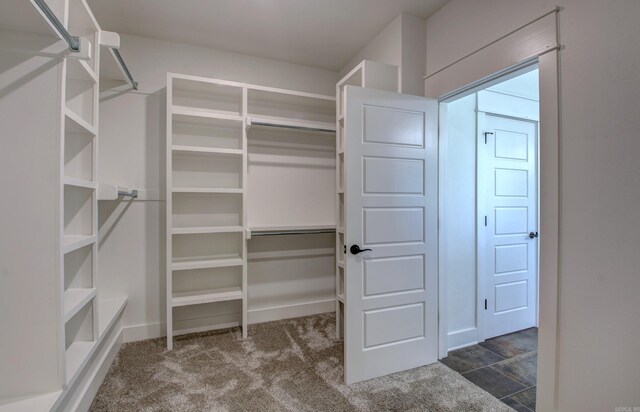 spacious closet featuring dark carpet