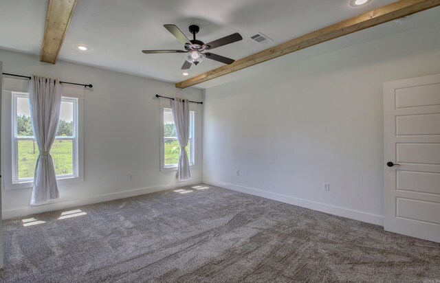 unfurnished room featuring carpet, beam ceiling, and ceiling fan