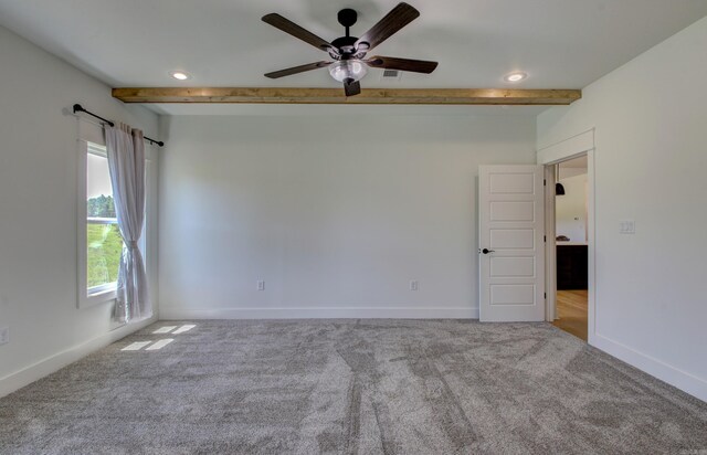 empty room with light colored carpet, ceiling fan, and beamed ceiling